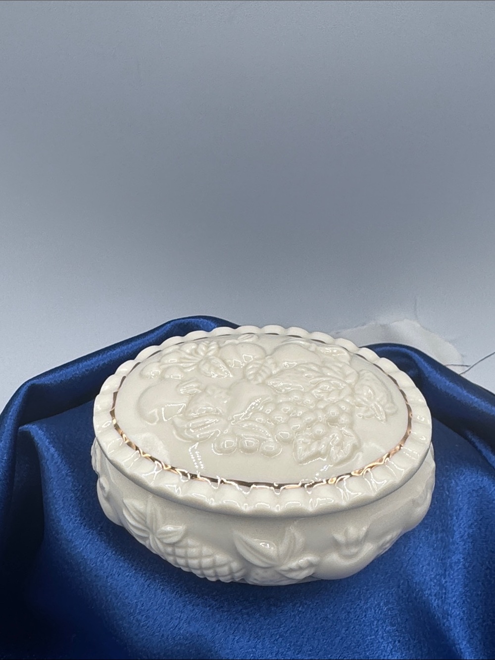 Lenox trinket box with a raised fruit/floral relief design with gold trim.